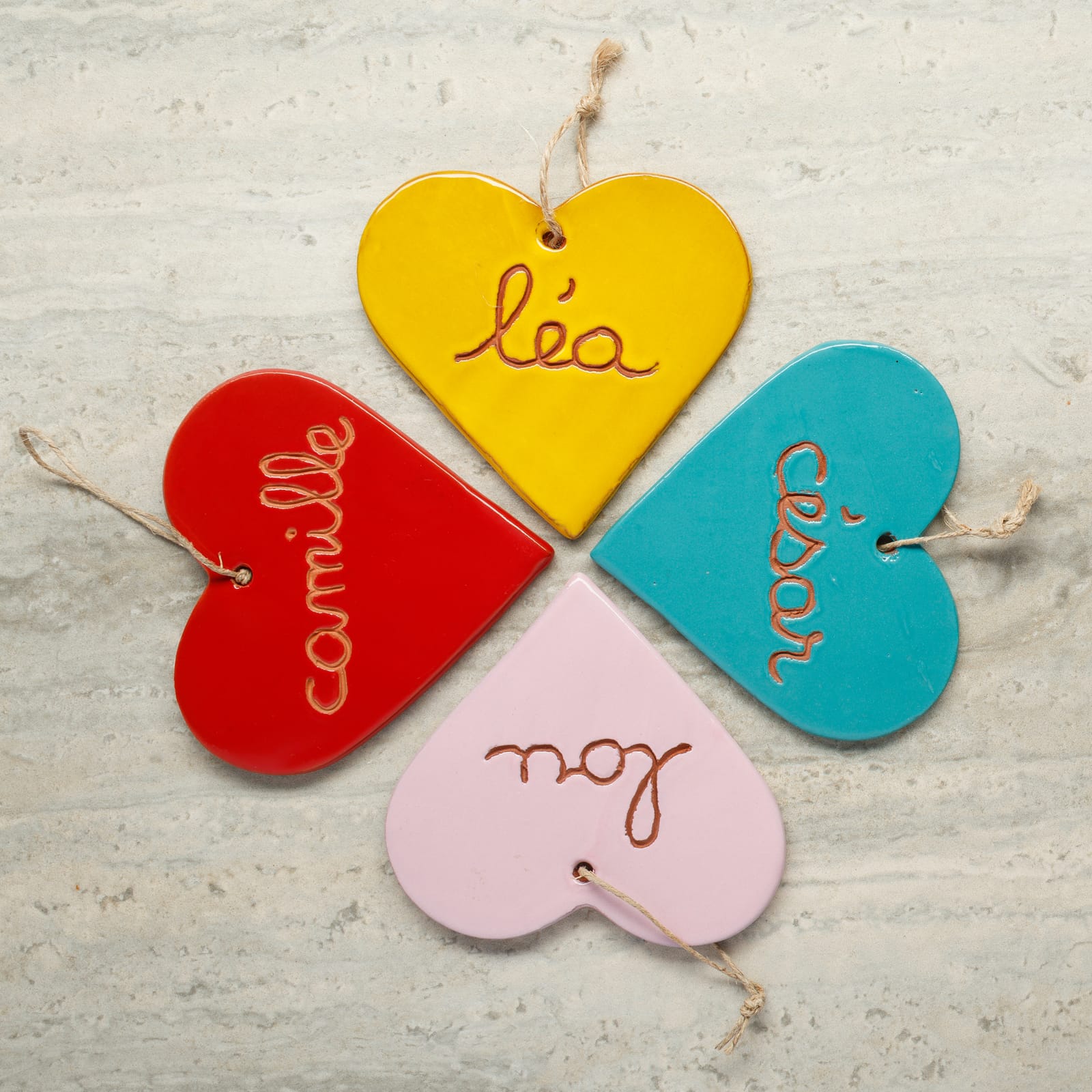 Quatre cœurs de couleurs différentes disposés en croix sur une pierre
